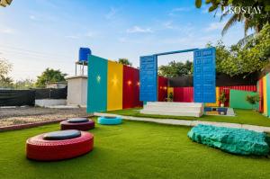 a house with colorful walls and green grass at EKOSTAY - Blue Door Villa in Alibaug