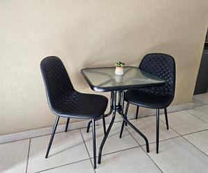 two chairs and a table with a potted plant on it at Oblique Boutique House in Centurion