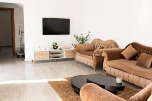 a living room with two couches and a tv at Villa Zain in Houmt Souk