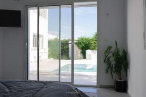 a bedroom with a sliding glass door with a potted plant at Villa Zain in Houmt Souk +19 photos