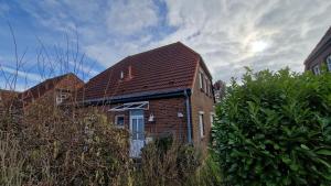 a brick house with a brown roof at Nr 97 - Ferienhaus Uferstraße in Carolinensiel