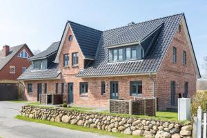 a red brick house with a black roof at Fennenblick in List