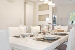 a white dining room with a white table with glasses at Fennenblick in List