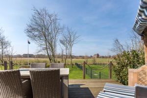 a patio with chairs and a table with a view of a field at Fennenblick in List +46 photos