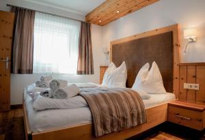 a bedroom with a large bed with white pillows at AKTIV Apartments by Peak Stay in Leutasch +42 photos