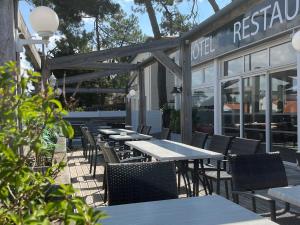a row of tables and chairs outside of a restaurant at Les Cols Verts - Logis Hôtels in La Tranche-sur-Mer