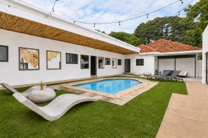 a backyard with a swimming pool and a house at Hunni Hotel Melrose Edge in Johannesburg