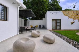 a patio with three concrete spheres on the ground at Hunni Hotel Melrose Edge in Johannesburg
