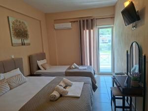 a hotel room with two beds and a television at Studio Lazaridi in Skala Rachoniou