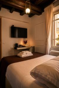 a bedroom with a bed with a television on the wall at Vicolo delle Belle Suite in Terracina