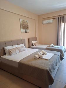 two beds in a hotel room with towels on them at Studio Lazaridi in Skala Rachoniou +10 photos
