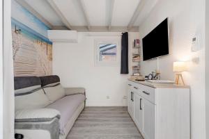 a living room with a couch and a tv at Villa ctl - carcans, médoc in Maubuisson