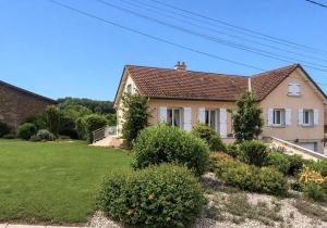a house with a green yard with bushes at Charmant et sans chichis in Montlibert