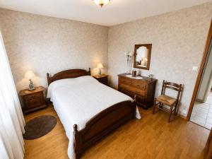 a bedroom with a bed and a mirror and a chair at Charmant et sans chichis in Montlibert