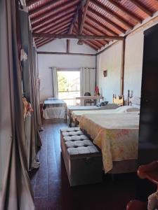 a large room with two beds and a window at Chalé da Estação in Carrancas