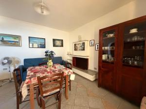 a dining room with a table and a blue couch at La Casa Gialla in Cala Gonone +9 photos