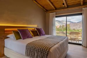 a bedroom with a bed and a large window at Alma de Purmamarca in Purmamarca