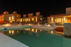a swimming pool with lounge chairs in front of a house at Alma de Purmamarca in Purmamarca