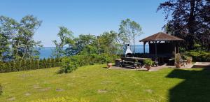 a gazebo in a field with the ocean in the background at Residenz Seeblick Whg 4, mit Gartenzugang in Ostseebad Sellin