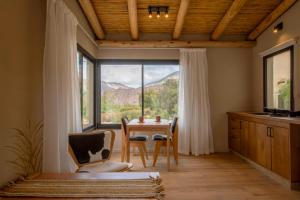 a kitchen with a table and chairs and a large window at Alma de Purmamarca in Purmamarca