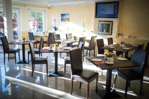 a dining room with tables and chairs in a restaurant at Hotel Sonnenklahr mit Pool in Göhren
