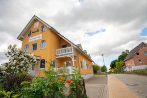 a yellow building on the side of a street at Hotel Sonnenklahr mit Pool in Göhren