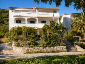 a building with a retaining wall in front of it at Pljesa Apartments -Meerblick mit Terrasse & Grill by rentyourhome24 in Supetarska Draga