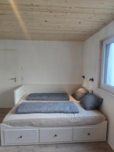a bed in a bedroom with a wooden ceiling at Bodensee Living Ferienwohnung Wald in Wald