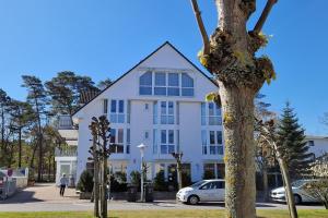 a white building with a tree in front of it at Ferienwohnung Graugans in Baabe