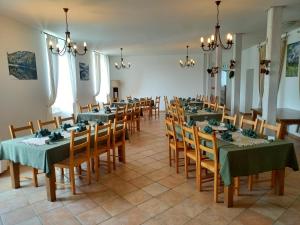 a dining room with tables and chairs with green tablecloths at Le Clos Auvergnat in Tauves