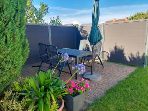 a patio with a table and chairs and an umbrella at Ferienwohnung Haus Möwe in Freest