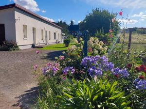 a garden of flowers in front of a building at Ferienwohnung Haus Möwe in Freest