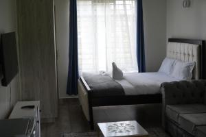 a bedroom with a bed with a laptop on it at Elite Escape in Muchatha