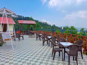 a row of tables and chairs on a patio at Aurevelle Kastura Resort Kanatal - Mountain View Rooms in Kanatal