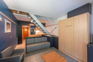 een woonkamer met een bank en een trap bij Vayamundo Houffalize in Houffalize