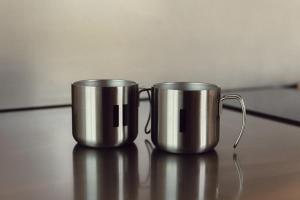 two metal coffee mugs sitting on top of a table at Dvoye in Vodniki