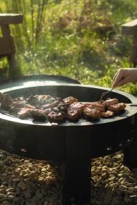 a person is cooking meat on a grill at Dvoye in Vodniki