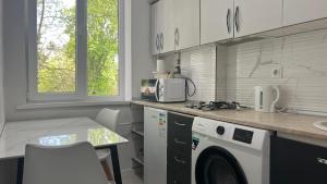 a kitchen with a washing machine and a microwave at New 2 ROOM ultra centr in Bălţi