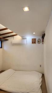 a bedroom with a white bed and a clock on the wall at Sungsim Hanok Guesthouse in Jeonju