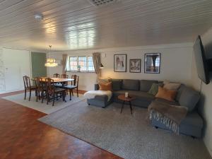 a living room with a couch and a table at Family-friendly house near Söderåsen Natinal Park in Slättåkra