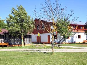 a building with a tree in the grass next to a sidewalk at Ferienhof Gold in Waischenfeld