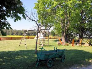a wheelbarrow sitting in a park with a playground at Ferienhof Gold in Waischenfeld +70 photos