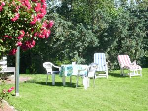three chairs and a table in the grass at Ahlborns Bluetenhof in Jork