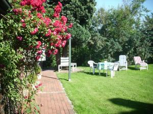 a garden with chairs and a table and flowers at Ahlborns Bluetenhof in Jork