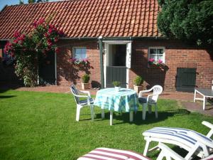 a table and chairs in the yard of a house at Ahlborns Bluetenhof in Jork