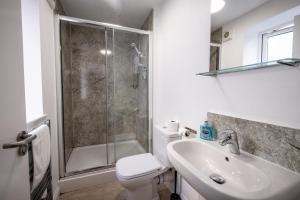 a bathroom with a shower and a toilet and a sink at Morecambe Rooms in Morecambe
