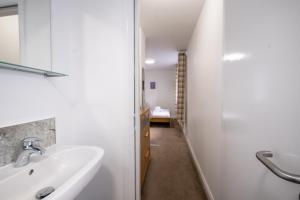 a white bathroom with a sink and a hallway at Morecambe Rooms in Morecambe