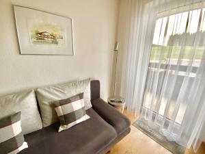 a living room with a couch and a large window at Hubertushof in Jungholz +48 photos