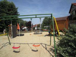 an empty playground with two swings in the sand at Ferienhaus Deichgraf 65 im Feriend in Hollern-Twielenfleth