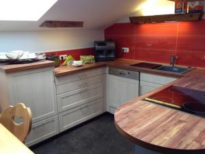 a kitchen with white cabinets and a wooden table at Landhaus Rossberg in Tannheim